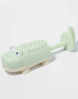 Világoszöld krokodil formájú műanyag húzható gyerekjáték fehér háttéren