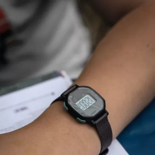 Digitális gyerek karóra fekete szíjjal, közelkép viselés közben