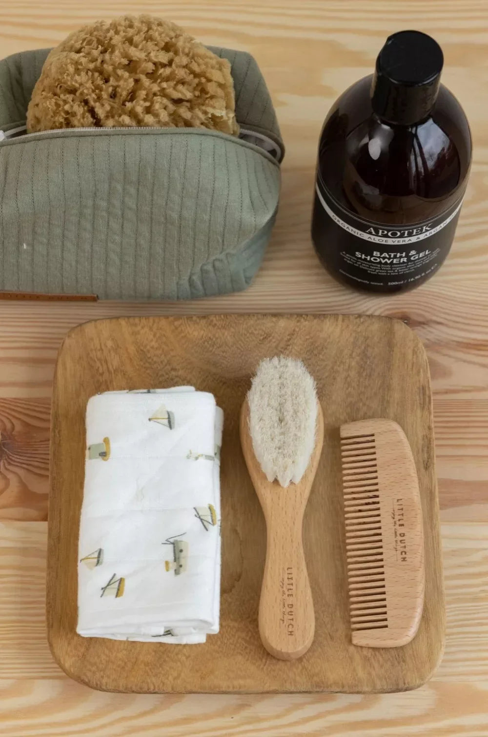 Baba fürdető szett: fa fésű, puha kefe, törölköző, natúr fürdőszivacs és fürdőgél.