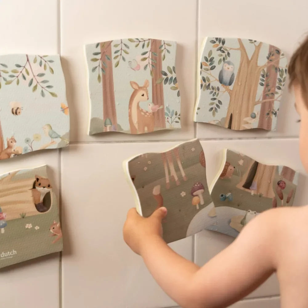 Gyerek interaktív habszivacs erdei állatos puzzle lapokat rak a fürdőszoba falára.