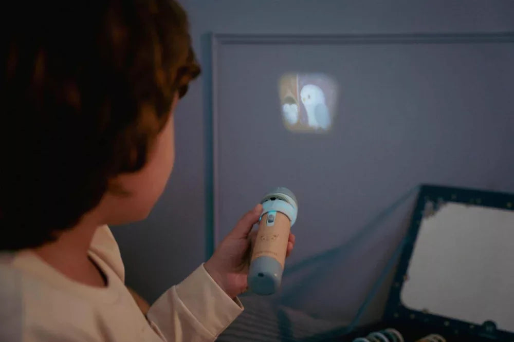 Gyerek diavetítővel vetít mesét a falra, interaktív játék gyerekszobában