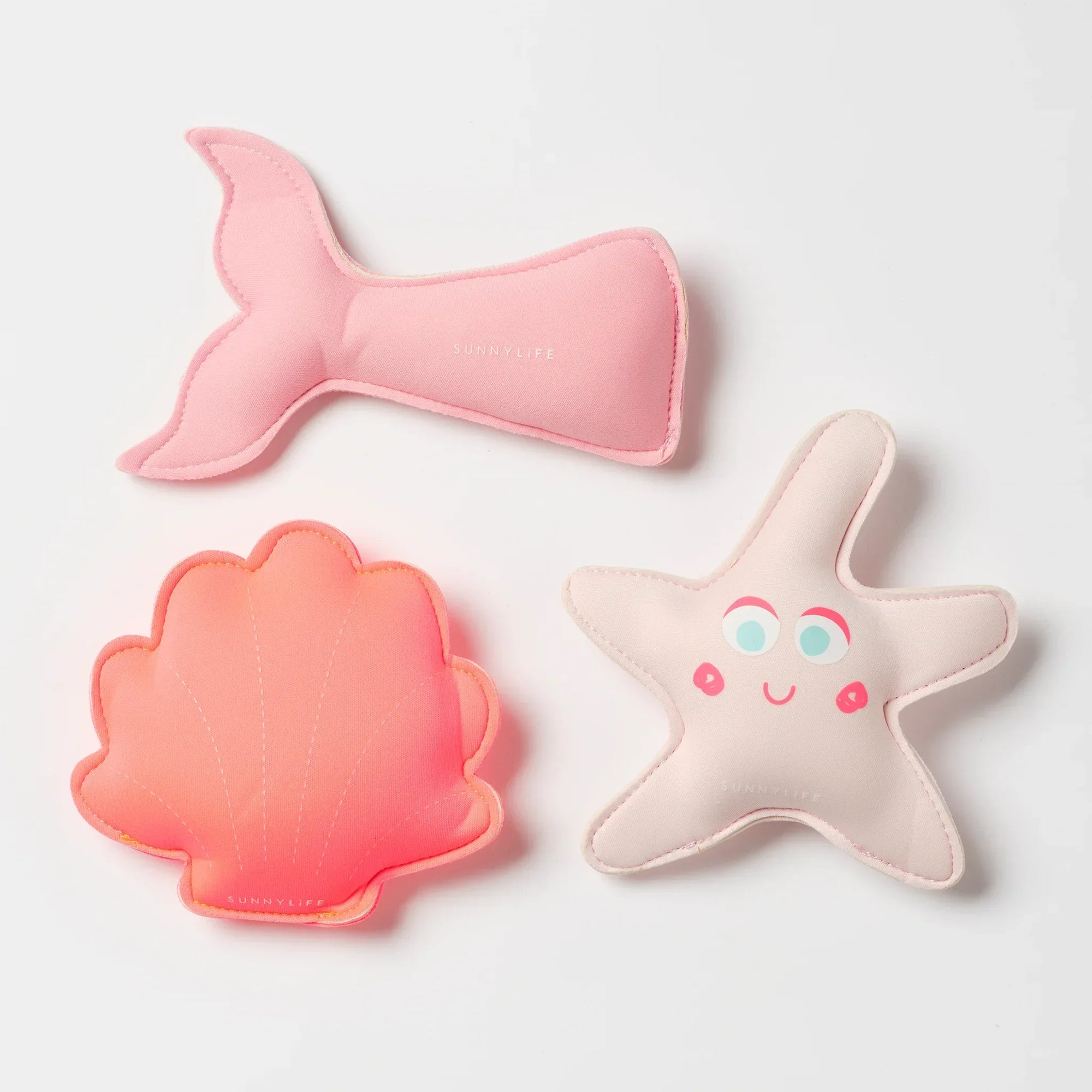 Vidám tengericsillag, kagyló és sellőfarok formájú puha gyerekjátékok fehér háttéren