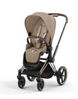 Bézs színű, prémium, négykerekű babakocsi állítható napellenzővel és ülőrészével.